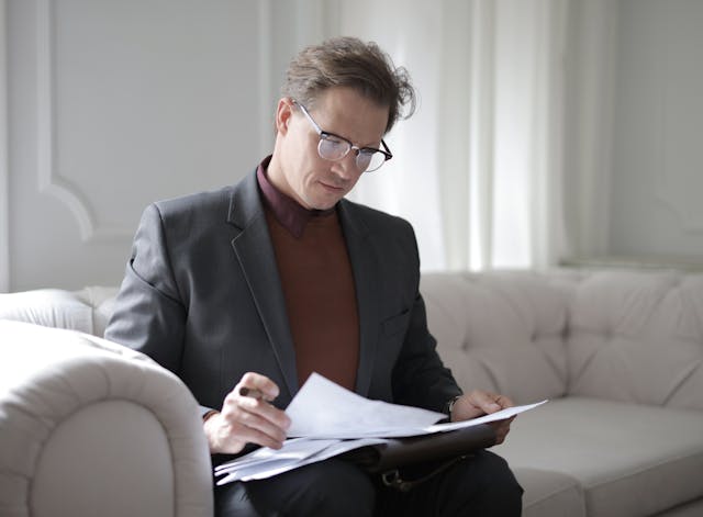 A property manager sitting on a couch going over a leasing agreement